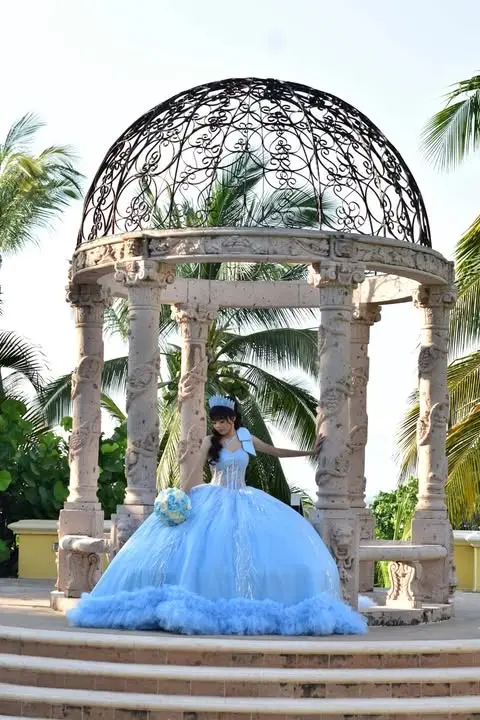 Tiffany Itzel bajo un kiosco rodeado de palmeras